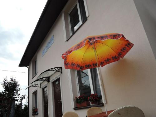 an der Gebäudeseite ist ein Regenschirm befestigt in der Unterkunft Topaz, holiday house in Wapnica in Wapnica