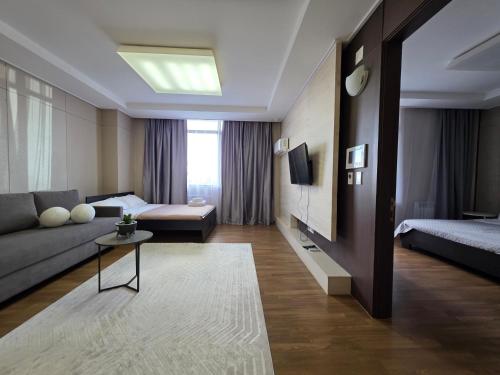 a living room with a couch and a bed at 206 Luxury Апартаменты с шикарным видом на Мечеть Хазрет Султан,2х комн с 2-мя кроватями и раскладным диваном,2 санузла in Astana