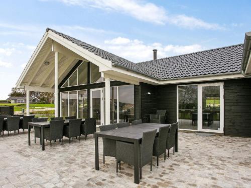 a patio with a wooden table and chairs at 18 person holiday home in Faaborg in Fåborg