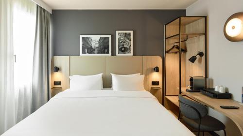 a hotel room with a bed and a desk at Campanile Paris Est - Pantin in Pantin
