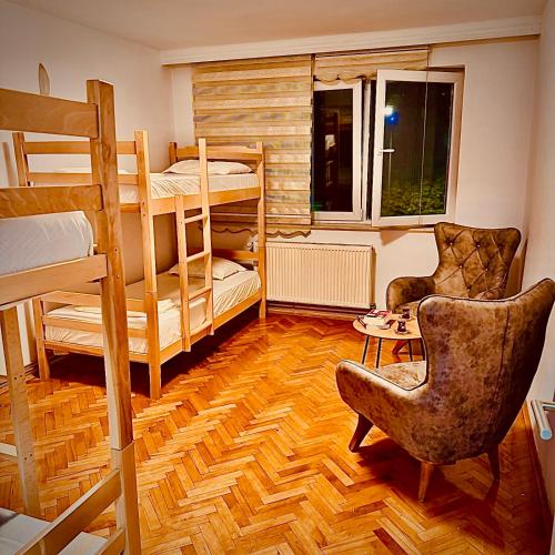 a room with two bunk beds and a chair at Center House Hostel v2 in Pristina