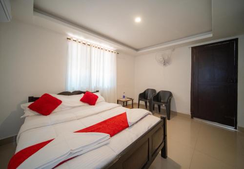 a bedroom with a bed with red pillows on it at Munroe Island Lake Resort in Kollam