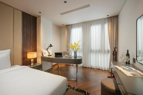 a hotel room with a bed and a desk and a bedroom at Léman Old Quarter in Hanoi