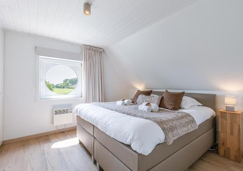 a bedroom with a large bed with two teddy bears on it at Vakantiehuis van Damme tot duin in Damme