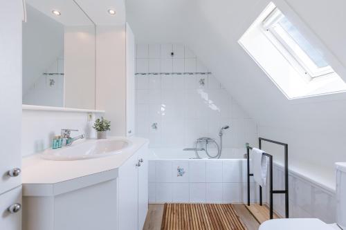 a white bathroom with a sink and a toilet at Vakantiehuis van Damme tot duin in Damme