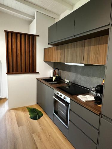a kitchen with gray cabinets and a wooden floor at Como's Hill Apartments - Foresta in Lipomo