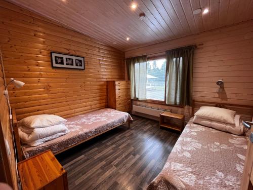 a bedroom with two beds in a log cabin at Motelli Rovaniemi in Rovaniemi