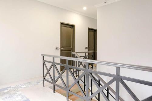 a staircase with a metal railing and two doors at Panorama Inn Residence Batu Redpartner in Batu