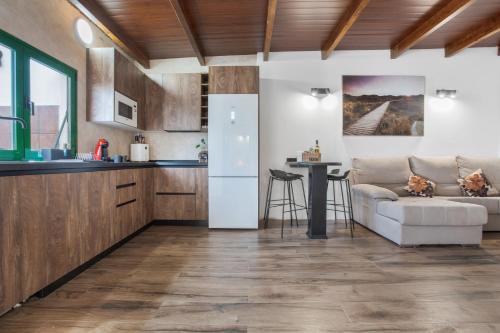 a kitchen and living room with a couch and a table at El Refugio De Los sueños in Uga