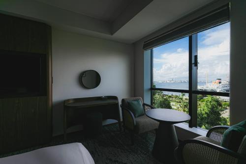 a hotel room with a bed and a desk and a window at The Gate Hotel Yokohama by Hulic in Yokohama