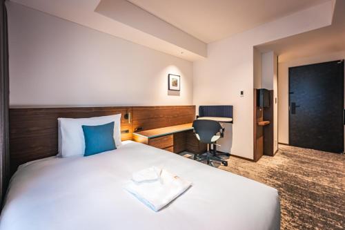 a hotel room with a bed and a desk at The Gate Hotel Yokohama by Hulic in Yokohama