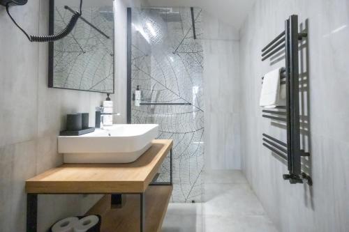 a white bathroom with a sink and a mirror at 4 Évszak Hegyihotel in Mátraháza