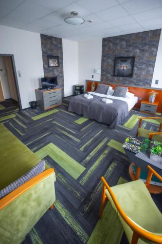 a hotel room with a bed and a table and chairs at 4 Évszak Hegyihotel in Mátraháza