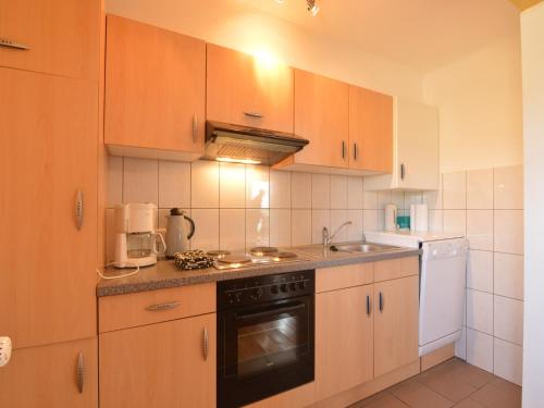 a kitchen with wooden cabinets and a stove top oven at Apartment in Halenfeld-Amel with Terrace in Amblève