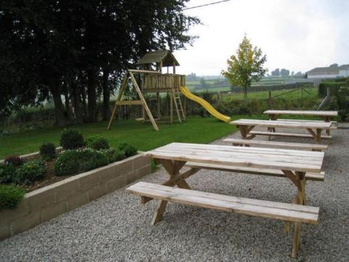 two picnic tables and a playground with a slide at Apartment in Halenfeld-Amel with Terrace in Amblève