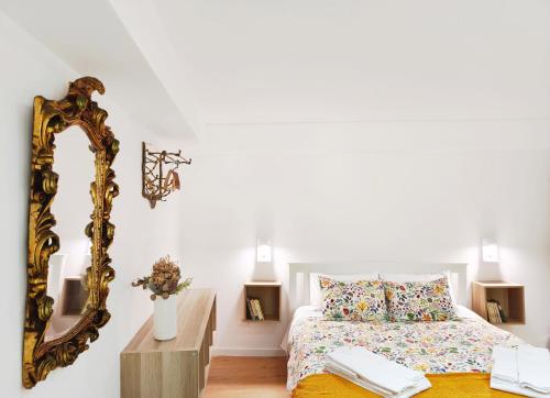 a bedroom with a bed and a mirror at Retiro da Igreja by Casas do Planalto in Torre de Moncorvo