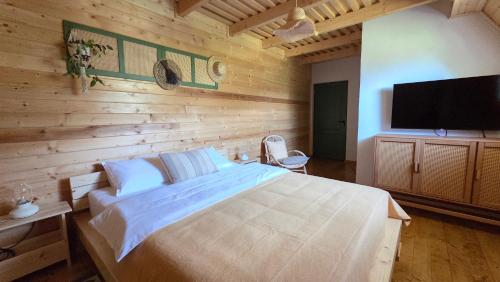 a bedroom with a large bed and a flat screen tv at Deja View Cabin & Camp in Rogojel