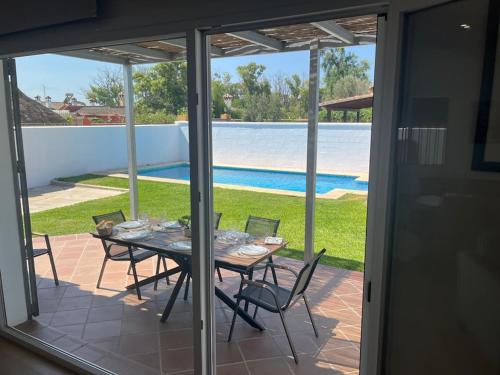 a table and chairs on a patio with a view of a pool at Sunset Palm in El Puerto de Santa María