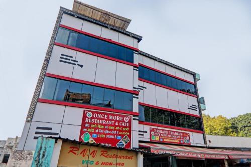 a tall white building with signs on it at Hotel O ONCE MORE RESTAURANT AND CAFE in Prayagraj