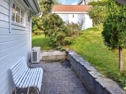 a white bench sitting next to a house at Family Oasis with Lake View-By Traum in Ålesund