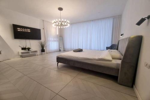 a large bedroom with a bed and a television at אחוזת מיתרים in Kallanit