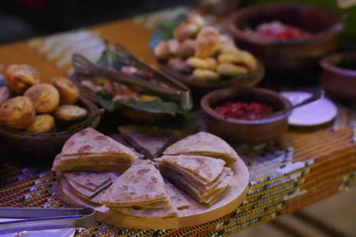 a table with a plate of sandwiches and other foods at Paje By Night Bungalows in Paje