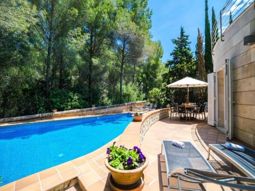 a swimming pool with a table and chairs next to a house at Villa in Alcúdia near Sandy Beach in Alcudia