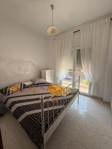 a bedroom with a bed and a large window at Alex Apartment in Nea Fokea