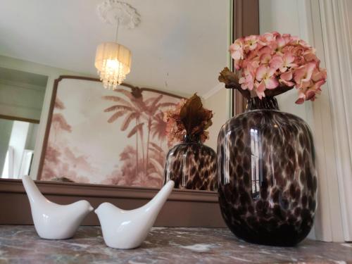 two black and white vases with flowers on a table at Ô Bulles de Loire, Châteauneuf-sur-Loire in Châteauneuf-sur-Loire
