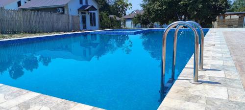 a swimming pool with a metal rail in the water at Events Park Qebele in Gabala