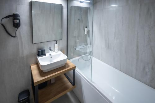 a bathroom with a sink and a mirror and a tub at 4 Évszak Hegyihotel in Mátraháza