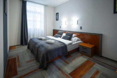 a bedroom with a large bed and a window at 4 Évszak Hegyihotel in Mátraháza