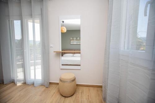 Un dormitorio con un espejo y un taburete en una habitación. en Elea Home, en Nea Vrasna