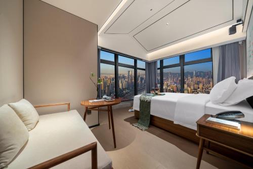 a bedroom with a bed and a large window at Chongqing Xingcheng Chengyijing Hotel Management Co., Ltd in Chongqing