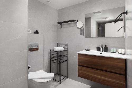 a bathroom with a toilet and a sink and a mirror at Luxury Apartments And Studios At Sea Side By Rently in Eilat