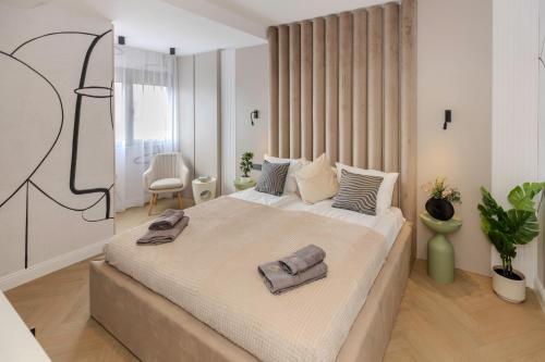 a bedroom with a large bed with two towels on it at AIASTAY Bucharest River Apartments in Bucharest