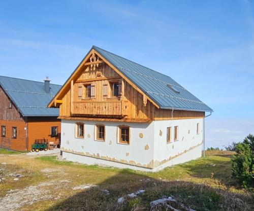 a house with a metal roof on top of a field at Erlakogelhütte am Feuerkogel in Oberlangbath