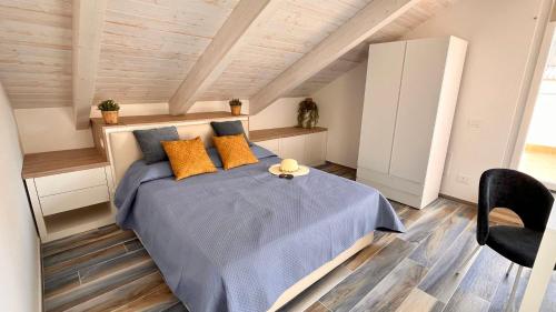 1 dormitorio con 1 cama con sábanas azules y almohadas de color naranja en Mansarda Oblique, en Maiori