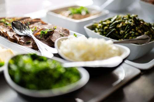a table with plates of food and bowls of rice at Rathener Hof by STEIGER Hotels in Kurort Rathen