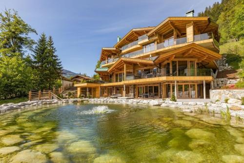 a house with a large pond in front of it at Chalet Residenz Mühlermoos - Terrassen Chalet in Ramsberg