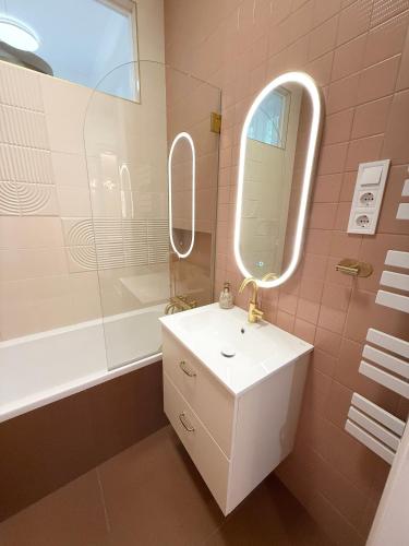 a bathroom with a sink and a mirror and a tub at Mirage Medic Hotel in Budapest