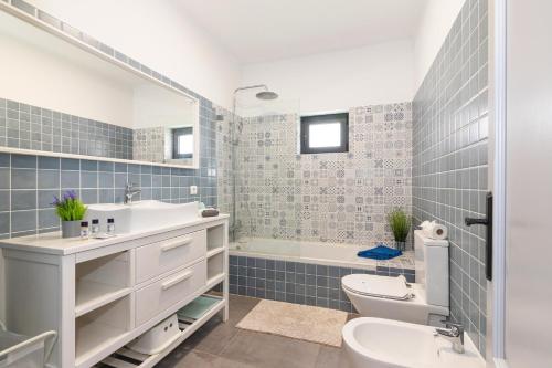 a bathroom with a sink and a toilet and a tub at Casa das Laranjeiras - Portimao in Portimão