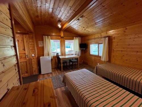 a bedroom with two beds and a desk in a cabin at Motelli Rovaniemi in Rovaniemi
