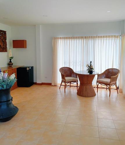 a living room with a table and chairs at The Rinra Kamala Hut in Kamala Beach