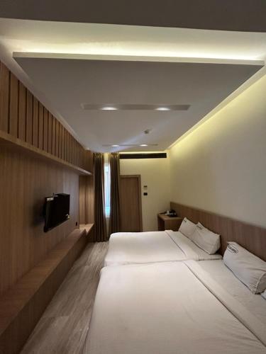 a hotel room with a large bed and a tv at Hotel Indian Imperial in Kumbakonam