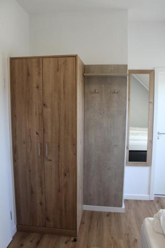a large wooden cabinet in a bedroom with a window at Doppelzimmer 2 in Lorup