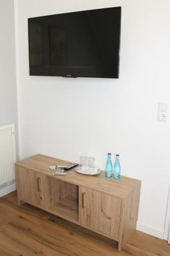 a television on a wall above a wooden coffee table at Doppelzimmer 2 in Lorup