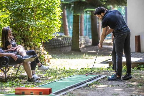 a man playing a game of golf with a woman at 4 Évszak Völgyhotel in Mátrafüred