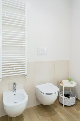 a white bathroom with a toilet and a sink at Civico 7 - Apulian Rooms in Conversano