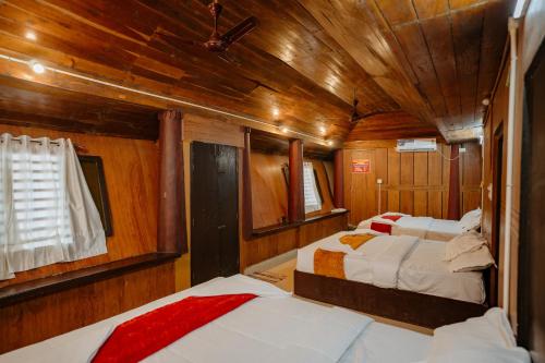 a bedroom with two beds in a wooden boat at Munroe Island Lake Resort in Kollam